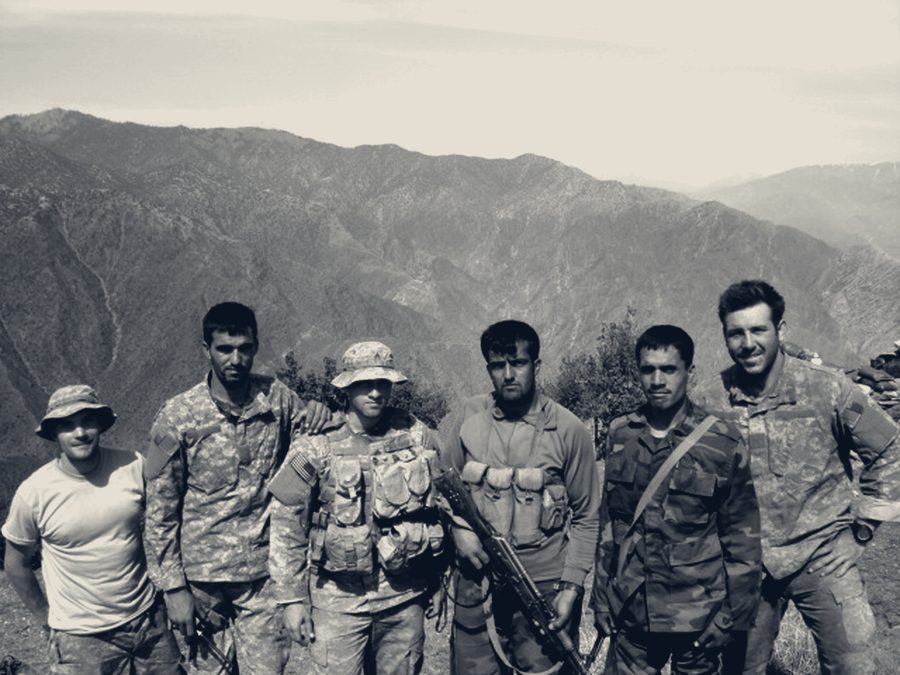 A combined patrol of U.S. soldiers and Afghan National Army partners standing together on a mountain ridge.
